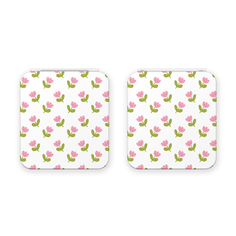 The Pink Tulips Game Card Box for Nintendo Switch by petimint is a pair of sleek, white square objects with rounded corners, showcasing a charming pattern of pink tulips with green stems and leaves. This delicately symmetrical floral motif adds an elegant touch that any gamer would appreciate as an accessory for their gaming space.
