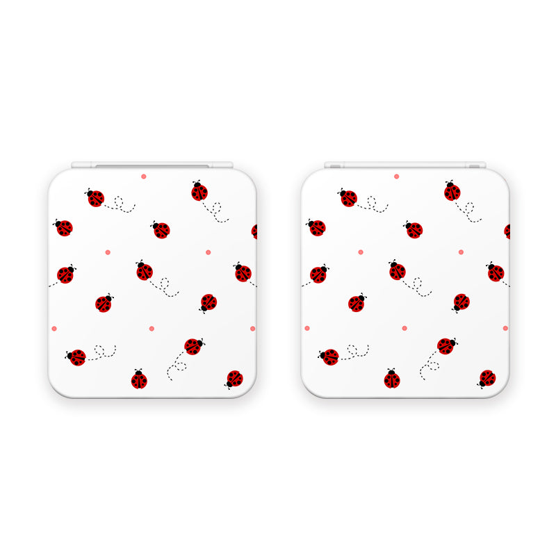 The Little Ladybug Game Card Box for Nintendo Switch by petimint is shown in white with a playful design featuring small red and black ladybugs scattered randomly, accompanied by light pink dots. The ladybugs are illustrated in various positions, creating an adorable pattern that's perfect for cozygamers or as a charming accessory.