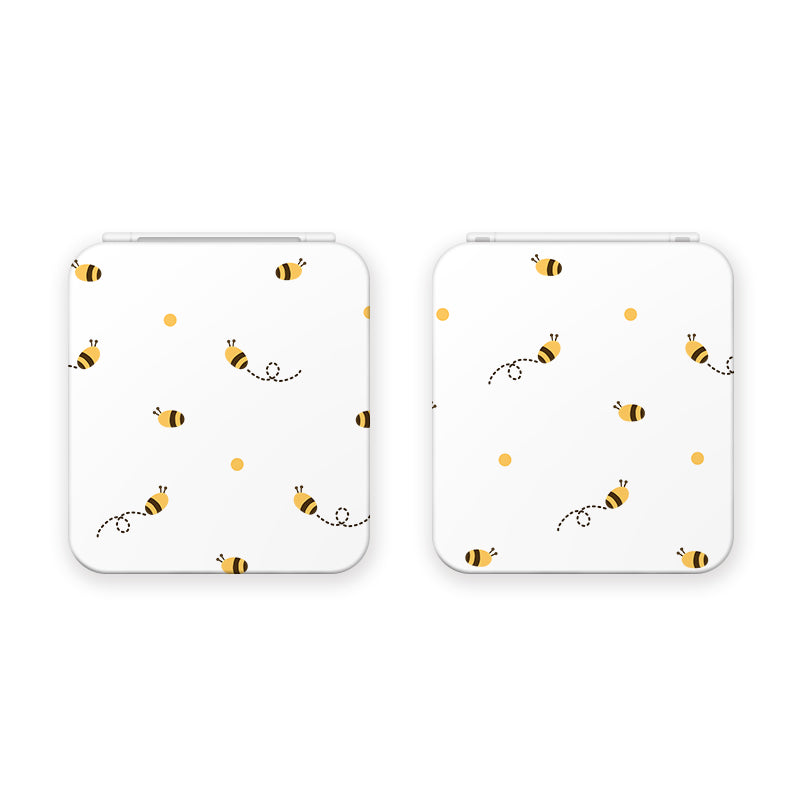 Two white Little Bee Game Card Boxes for Nintendo Switch by petimint feature a cute bee design perfect for any cozygamer. Each bee has a dotted line trail behind it, with small yellow dots scattered around, giving the pattern a simple and playful charm across the front surfaces of both gaming essentials.