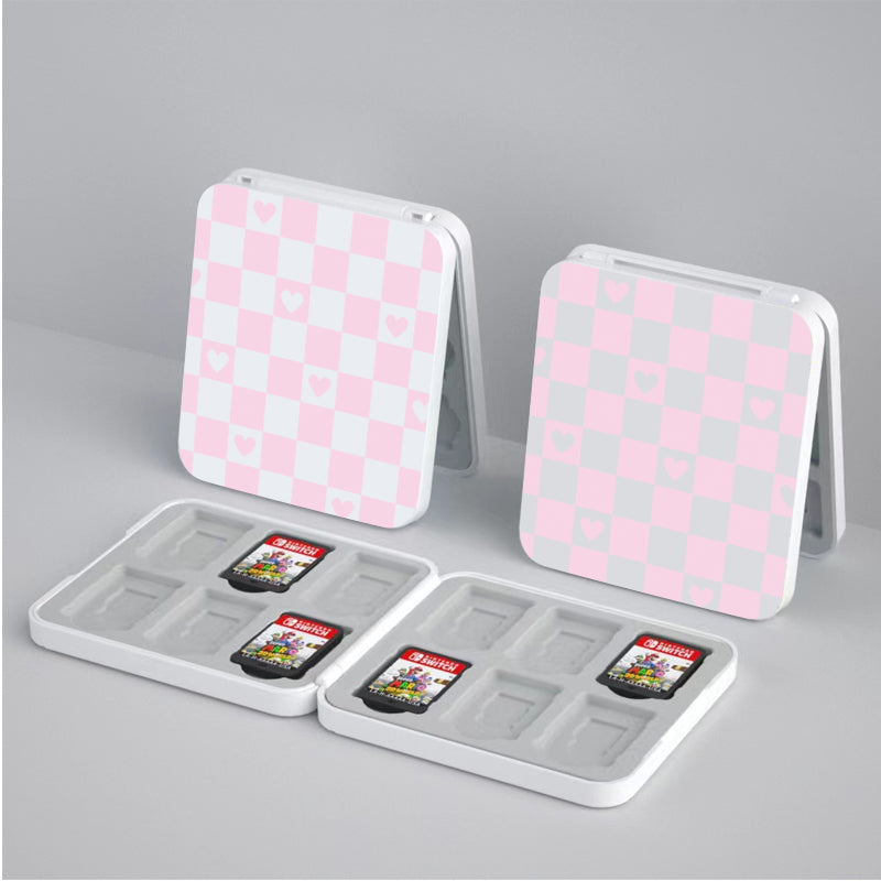 This image showcases two open petimint Checkered Love Game Card Boxes for Nintendo Switch, featuring a charming pink and white checkered pattern adorned with heart shapes. Each plastic case has multiple slots for storing game cartridges, some of which are filled while others remain empty.