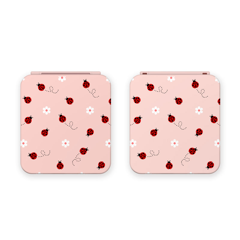 Two Little Ladybug Game Card Boxes for Nintendo Switch, both from the petimint brand, are displayed side by side. Each cover features a playful pattern of red ladybugs and white flowers with dotted paths on a light pink background. Ideal for the cozygamer, these boxes add a cute touch to your gaming setup, perfect next to your Nintendo Switch.
