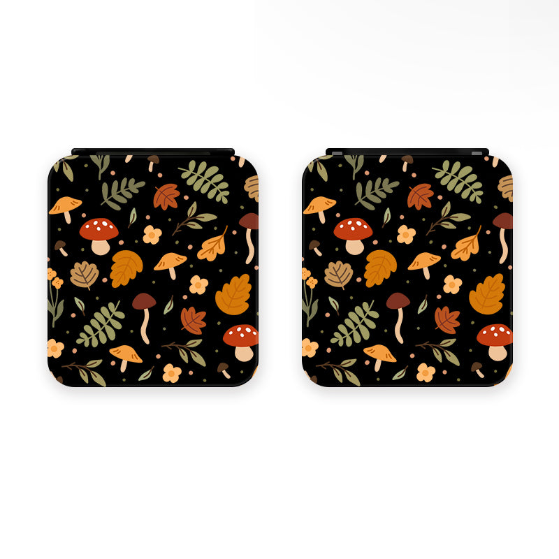 Two Cozy Autumn Game Card Boxes for Nintendo Switch by petimint with identical designs placed side by side. The design features a black background with a colorful autumnal pattern, including red and white mushrooms, various leaves, and small flowers in shades of orange, yellow, and green. Each box has a convenient magnetic closure.