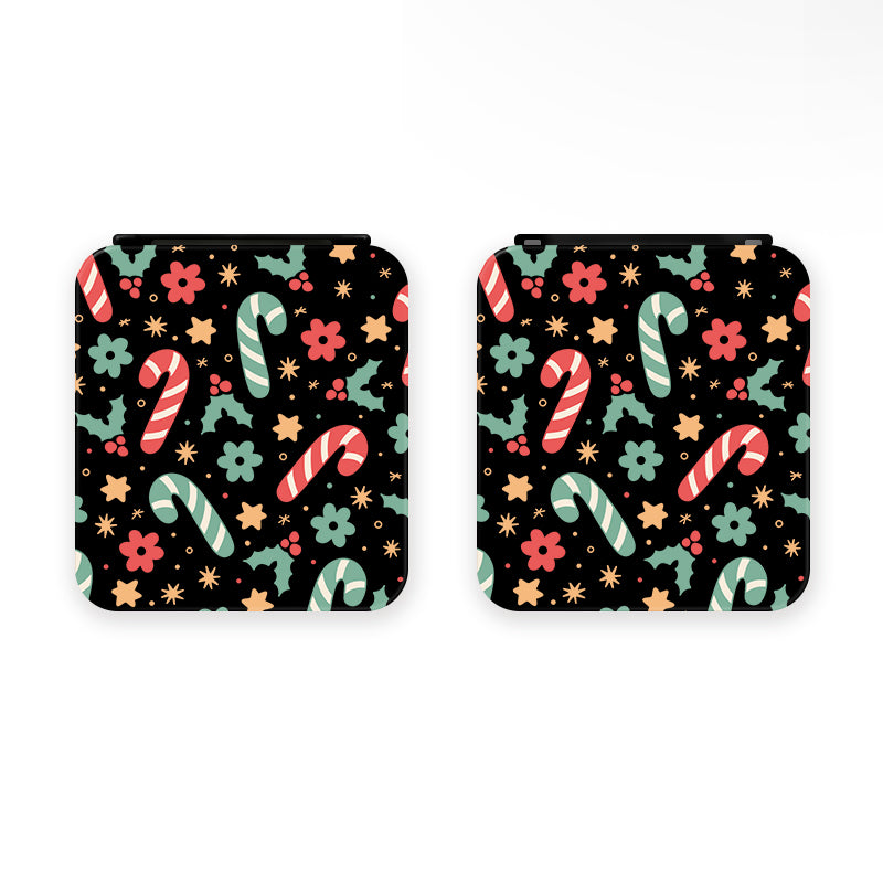 Two square coasters with rounded corners, featuring a festive pattern inspired by the Candy Cane Game Card Box for Nintendo Switch by petimint. The design includes striped candy canes, flowers, and stars in red, green, and yellow on a black background. Perfect for adding a touch of holiday cheer to any cozy gamer's setup.