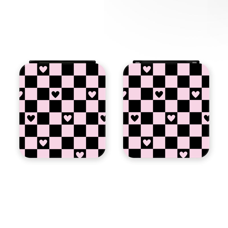Two square items, identified as the Checkered Love Game Card Boxes for Nintendo Switch by petimint, feature a pink and black checkerboard pattern with scattered pink hearts. Perfect for the cozygamer, this charming design is set against a plain white background.