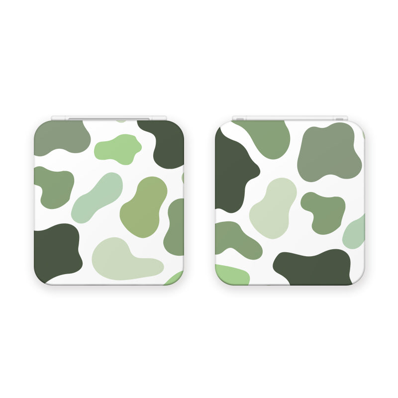 Two Matcha Cow Game Card Boxes for Nintendo Switch by petimint are displayed, each featuring a hinged lid and a green and white camouflage pattern. The design includes various shades of green in irregular shapes over a white background, reminiscent of gaming console aesthetics like the Nintendo Switch or themed apparel collections.
