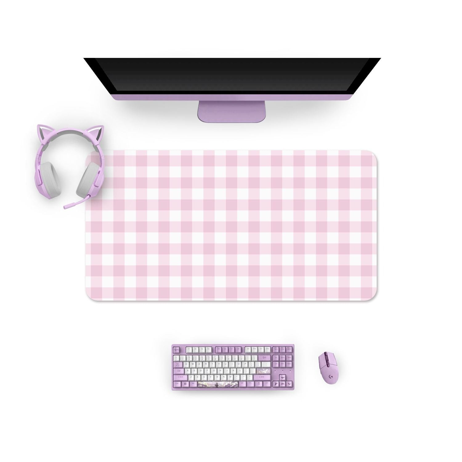 A computer workstation featuring a monitor, a purple keyboard and mouse, pink cat-ear headphones, and the "Picnic Mouse Pads Pc Gaming Accessories" by petimint in a large pink and white plaid pattern. The accessories are color-coordinated in shades of pink and purple. The view is from above, showcasing a tidy setup perfect for any cozygamer.