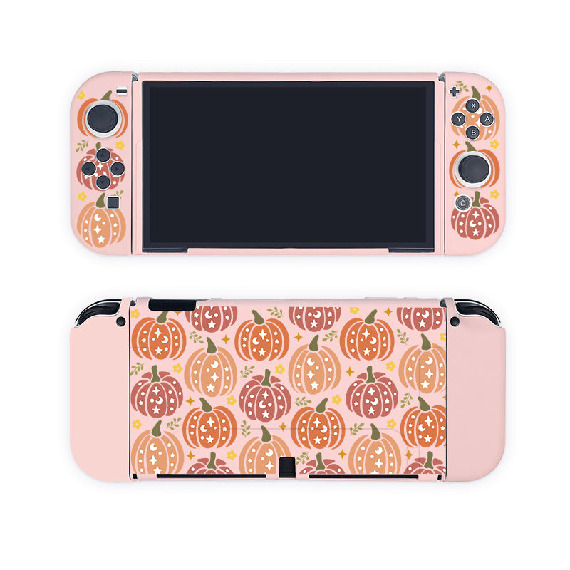 A Nintendo Switch encased in the petimint Pumpkins Case is shown from both front and back, adorned with a charming pastel pumpkin pattern. The design includes small, cartoon-like pumpkins in shades of orange, pink, and brown with green leaves. Perfect for the cozy gamer lifestyle, it features pink controllers attached on both sides.