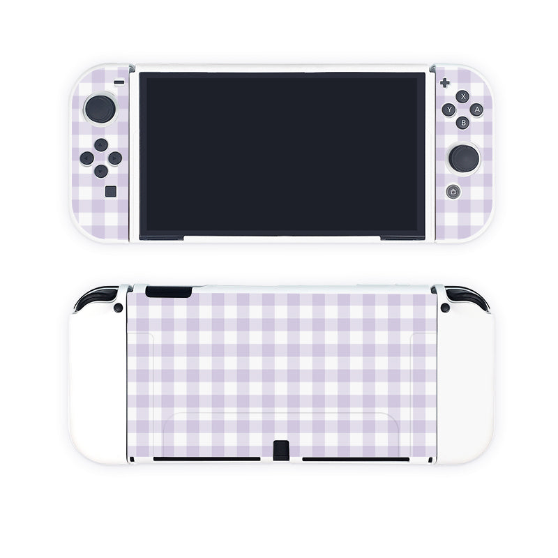 Introducing the Picnic Case for Nintendo Switch by petimint in a delightful light purple and white checked pattern. Perfect for the cozygamer, this accessory transforms your console with its charming design. The screen remains centered, flanked by detachable controllers adorned with various buttons, while the back of your Nintendo Switch enjoys the same stylish checked pattern, making it an eye-catching addition to your gaming setup.