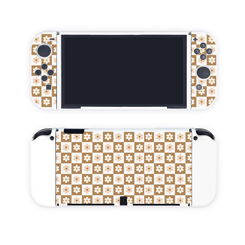 A Nintendo Switch console is showcased with the Cozy Checkered Flowers Case from petimint, featuring a white floral pattern on a beige checkered background. The image displays both the front and back of the console, highlighting the intricate design and the soft TPU material of this dockable case.