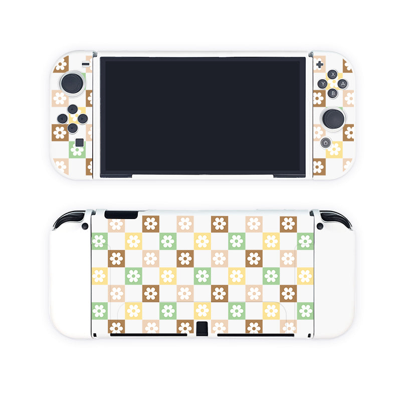 Introducing the Checkered Seasonal Flowers Case for Nintendo Switch by petimint, a handheld gaming console accessory in white with a charming floral pattern cover. Perfect for the cozygamer, it features a front display screen flanked by controls on either side. The back of the case showcases an intricate grid of green, brown, beige, and white squares, each adorned with a small flower in contrasting colors.