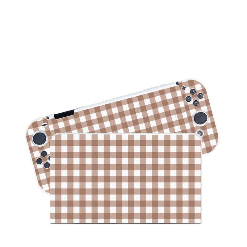The Picnic Case for Nintendo Switch by petimint offers a handheld gaming console and dock, both adorned with a charming brown and white checkered pattern similar to gingham, making them a cozygamer's delight. The console comes equipped with various buttons and joysticks, while the matching dock features the same endearing design.