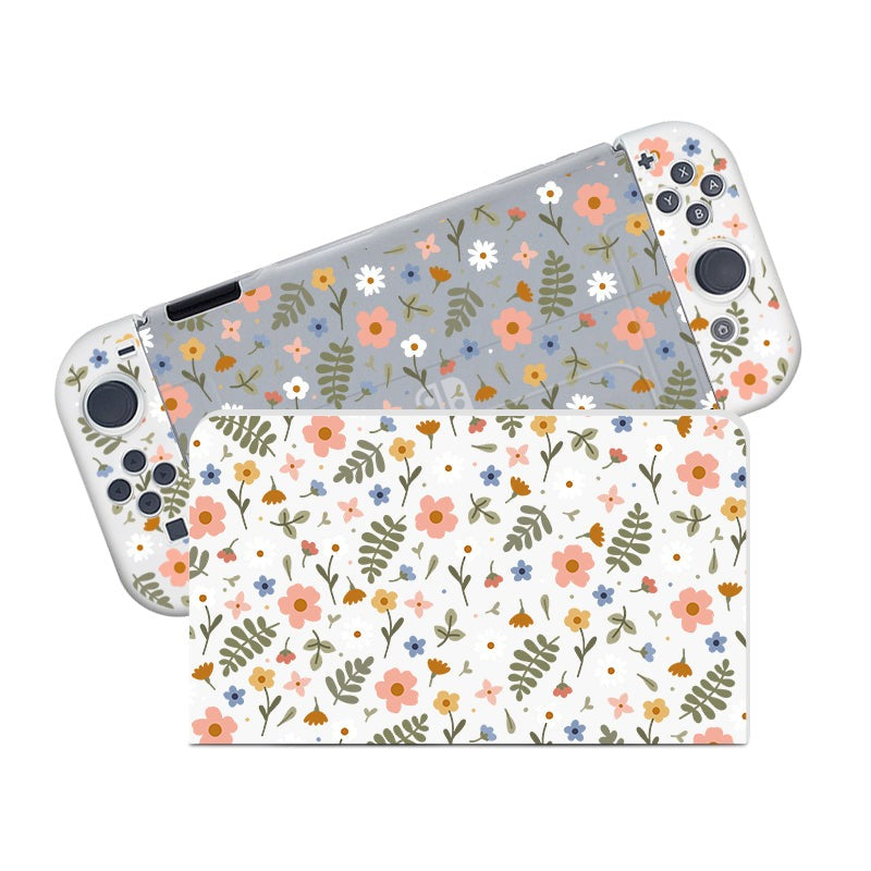 A cozygamer's dream, this petimint Spring Case for the handheld Nintendo Switch boasts detachable controllers adorned with a floral pattern cover. The design features flowers and leaves in shades of pink, orange, blue, and green on a white console with gray backgrounds, making the florals truly stand out.