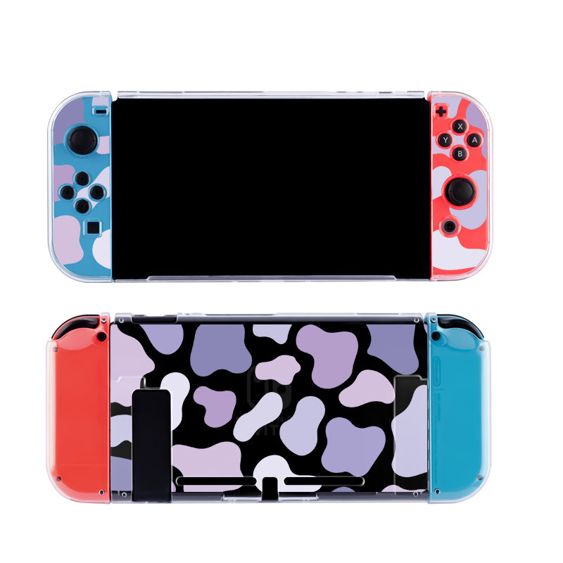 The Lilac Cow Case for the Nintendo Switch by petimint features detachable controllers on each side with a vibrant camo design. The front view showcases the screen and buttons with blue and red camo, while the back view highlights a cozygamer aesthetic in purple, black, and white camo patterns, complemented by an extended console stand. The case itself is clear.