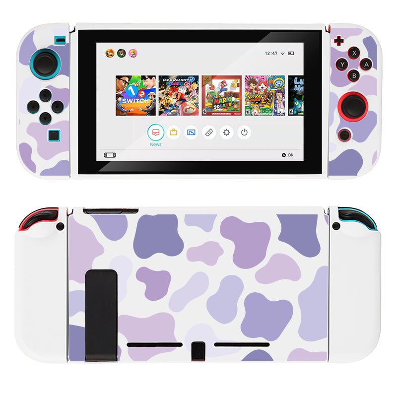 Image of a Nintendo Switch console adorned with the petimint Lilac Cow Case in white, featuring a pink and purple cow pattern. The screen showcases several game icons, including Animal Crossing, Super Mario Party, and Mario Kart 8 Deluxe. This stylish design is perfect for any gamer looking to add some flair to their Nintendo Switch setup.