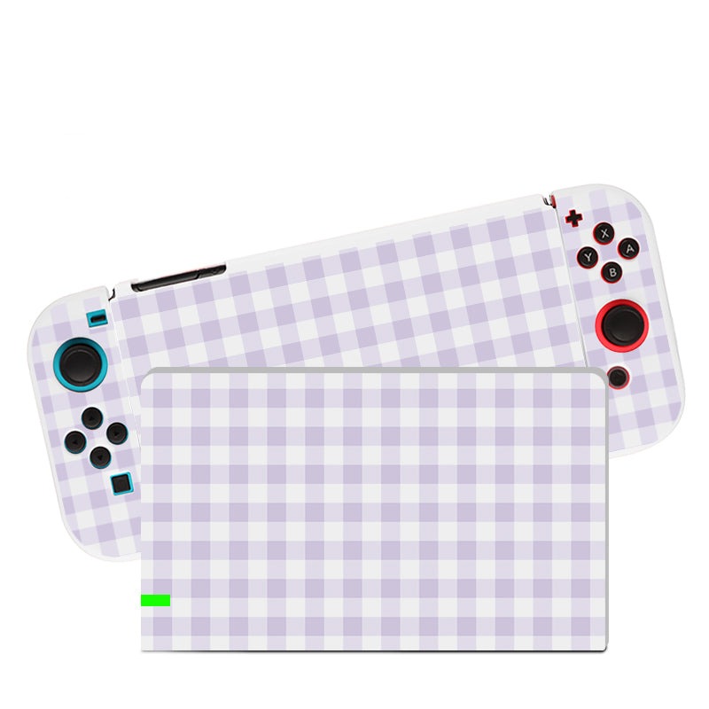 A Picnic Case for Nintendo Switch by petimint, featuring a checkered lavender and white design, is depicted. The handheld console has a screen in the center with control buttons on either side, encased in a soft TPU. The buttons are various colors, including blue, black, and red.