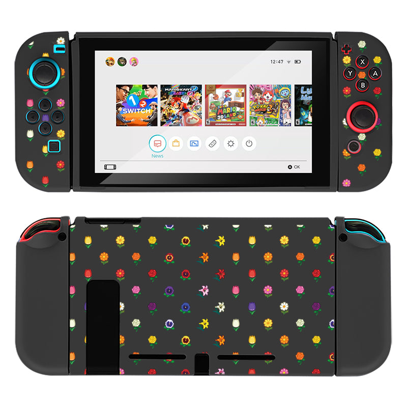 A handheld Nintendo Switch gaming console is encased in the stylish Flower Crossing Case by petimint, featuring a black color with a floral design on the joy-cons and back cover. The screen displays the main menu with several game icons, including "Super Mario" and "Mario Kart." The button colors and floral patterns are vibrant and varied, making it perfect for any stylish gamer.
