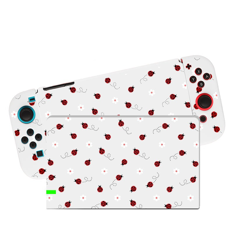 Check out the Little Ladybug Case for Nintendo Switch by petimint. This portable gaming console has a white design adorned with a pattern of red ladybugs and delicate flowers. It features blue and black buttons, joysticks on both sides, and a centrally located screen. For added comfort during extended gaming sessions, it includes a Soft TPU switch grip case.