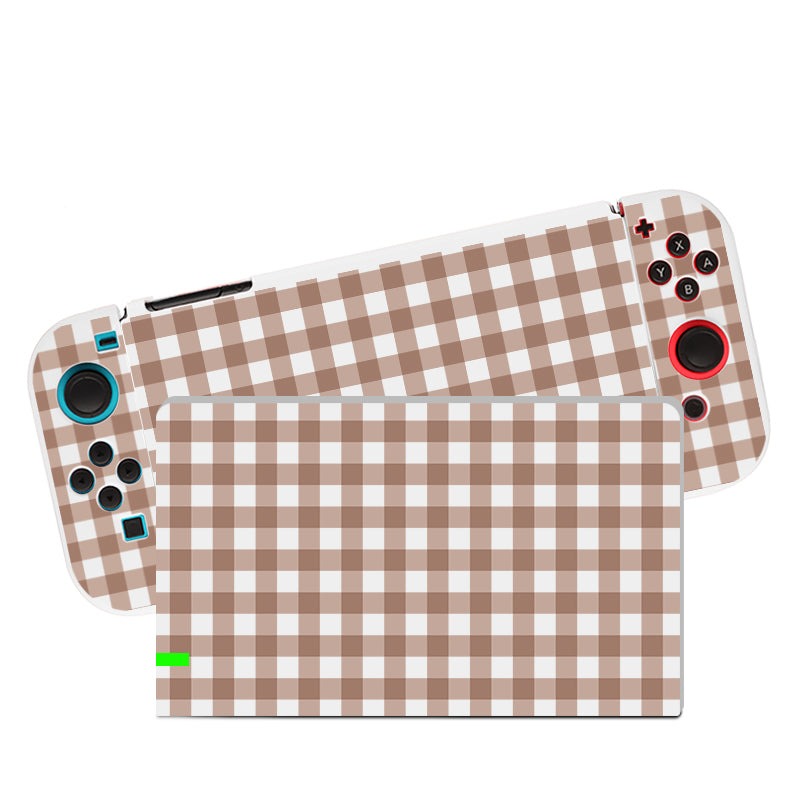 Introducing the Picnic Case for Nintendo Switch by petimint. This handheld gaming console features detachable controllers adorned in a stylish brown and white checkered design, covering the console screen and both controllers. The right controller showcases red buttons, while the left sports blue buttons. It also includes a soft TPU switch grip case in brown for enhanced comfort.