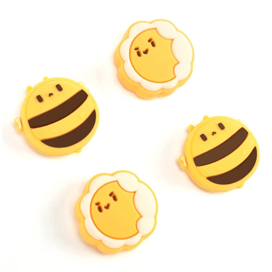 Four yellow and brown joystick caps, designed in the shape of cartoon-style bees with cute, simplistic facial features and fluffy wing patterns, are displayed against a white background. The petimint Bees Thumb Grips for Nintendo Switch add charm to any gaming setup with their scattered arrangement.