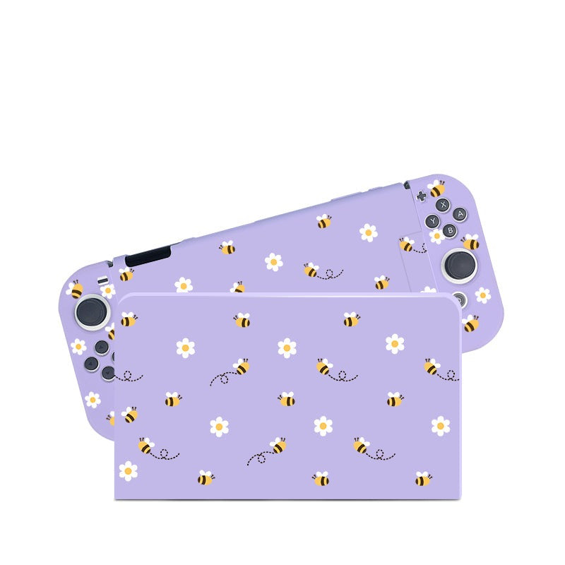 Introducing the Little Bee Case for Nintendo Switch by petimint—a must-have accessory for avid gamers. This charming case features a vibrant purple skin adorned with a delightful pattern of bees and white flowers, decorating both the front and back of your console to add a unique touch to your gaming gear.