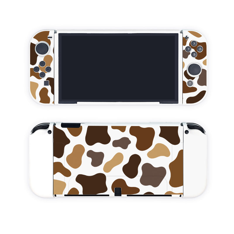 The product displayed is the Moka Cow Case for Nintendo Switch by petimint. Both the front and back of the case boast a cowhide-inspired pattern in brown, tan, and white. The screen is off, but buttons, joysticks, and directional pads are clearly visible on either side of it. This stylish accessory is perfect for any discerning gamer.