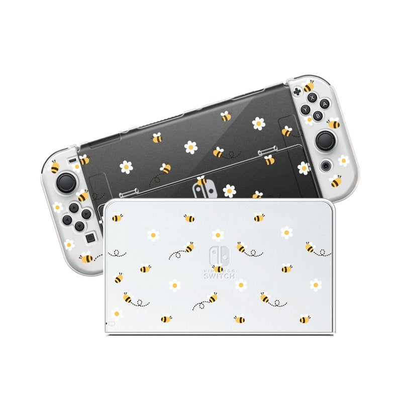 A Little Bee Case for Nintendo Switch by petimint, decorated with adorable bee and daisy patterns. The Joy-Con controllers are attached to the Nintendo Switch, which is positioned diagonally behind the dock. The design features small yellow bees and white daisies scattered across both items, making it perfect for any gamer.