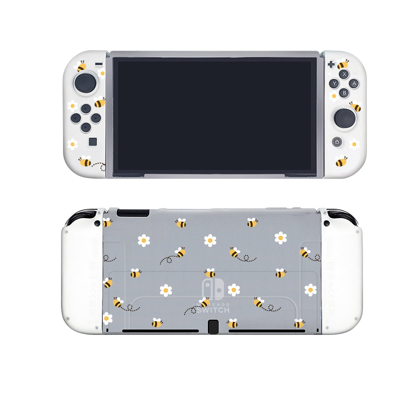 A cozygamer's delight: a Nintendo Switch encased in the Little Bee Case by petimint, featuring a semi-clear cover adorned with small bee stickers on the white Joy-Con controller set. The back of the console showcases a gray cover with charming bees and delicate white flowers, making it an ideal choice for any gamer. The console screen is turned off, awaiting your next adventure.