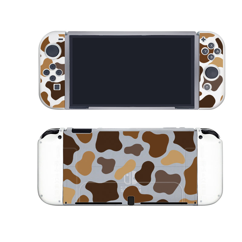 A handheld gaming console with a semi-clear Moka Cow Case by petimint, featuring a camouflage pattern in shades of brown, tan, and white on both the front and back. The screen is turned off, while the buttons and joysticks are visible on the front—perfect for any cozygamer looking to blend in while enjoying their Nintendo Switch games.