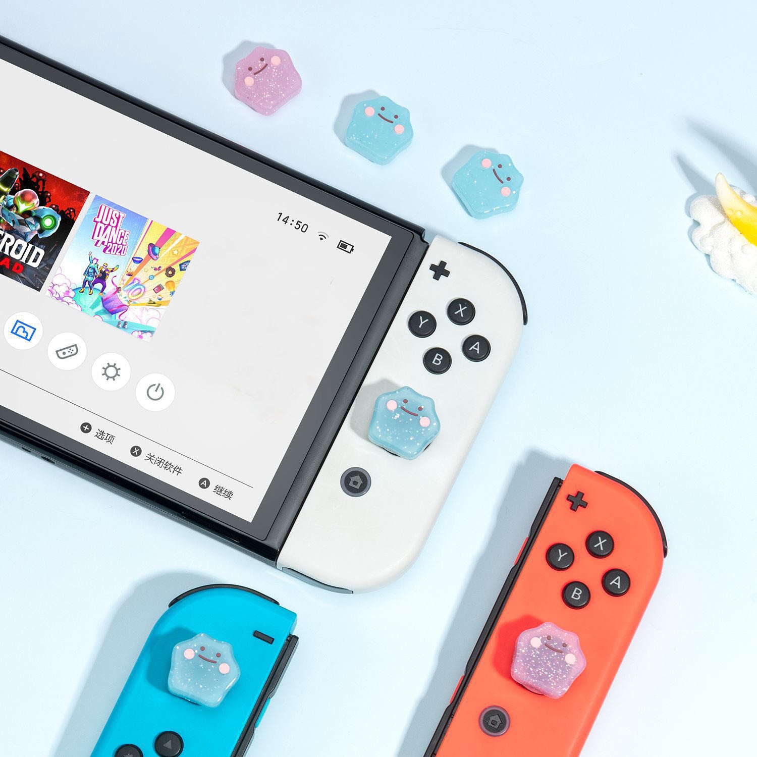 A Nintendo Switch console featuring white and colored Joy-Cons is displayed on a light blue surface. The Joy-Cons are adorned with pink and blue petimint Glitter Ditto Thumb Grips, adding a playful touch. The screen showcases a game selection menu, inviting endless adventures at your fingertips.
