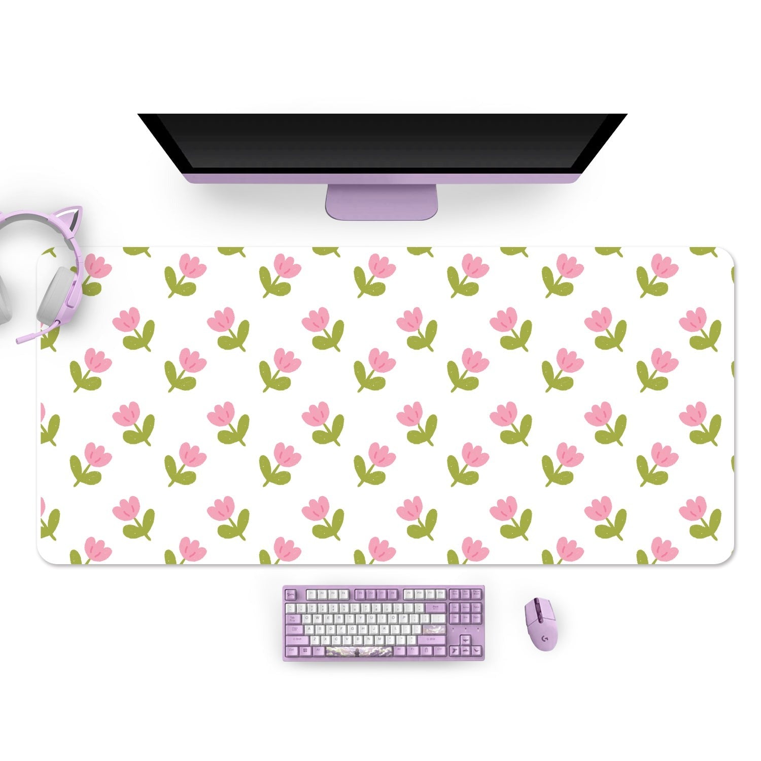 A cozy gamer workspace featuring the petimint Pink Tulips Mouse Pads PC Gaming Accessories—a large, white desk mat adorned with a pattern of pink tulips and green leaves. The setup includes a purple keyboard, mouse, and headphones, alongside a black-screen monitor and a nearby Nintendo Switch. The overall aesthetic is neat and stylish with a floral touch.