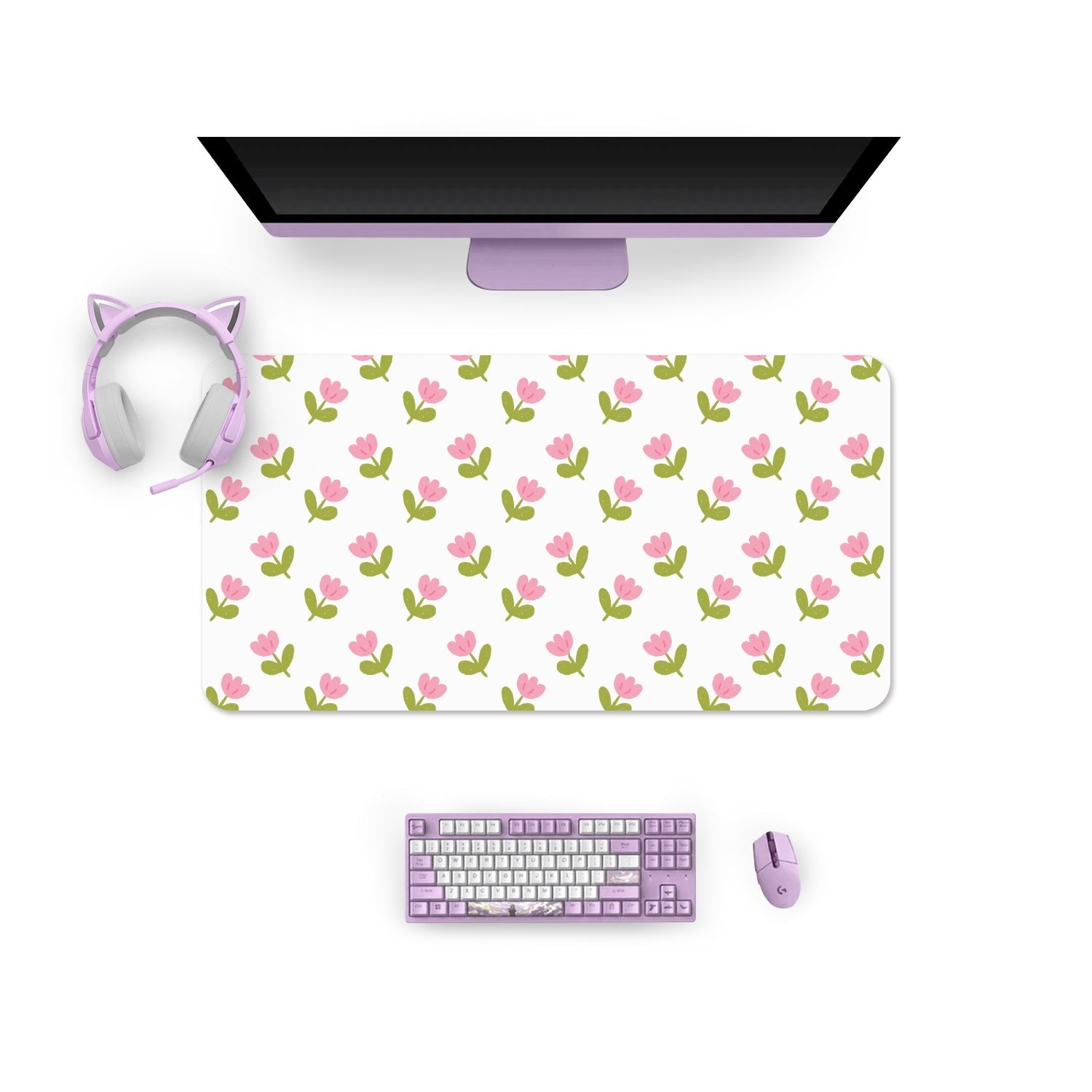 An overhead view of a computer desk setup with a monitor, a large petimint Pink Tulips Mouse Pad, a lavender keyboard, a lavender mouse, and lavender cat-ear headphones. The desk surface is white, creating a clean and coordinated look perfect for any cozygamer.