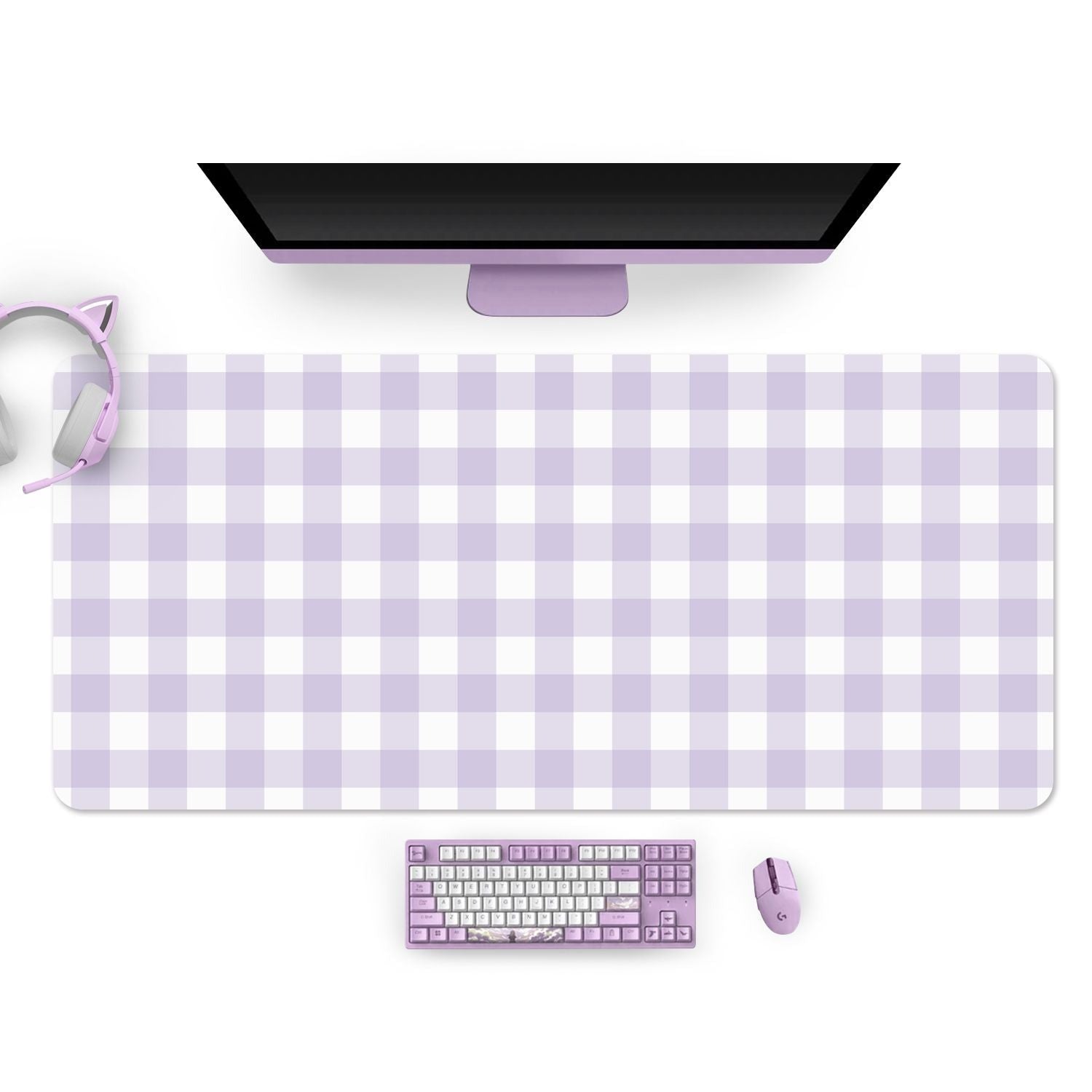 A computer desk setup with a pastel purple color theme, perfect for any gamer. It features a desktop monitor, a pastel purple gaming mouse, keyboard, and the petimint Picnic Mouse Pads Pc Gaming Accessories in lilac with checkered patterns in shades of purple and white. Headphones with purple ear pads and cat ears rest to the left of the monitor.